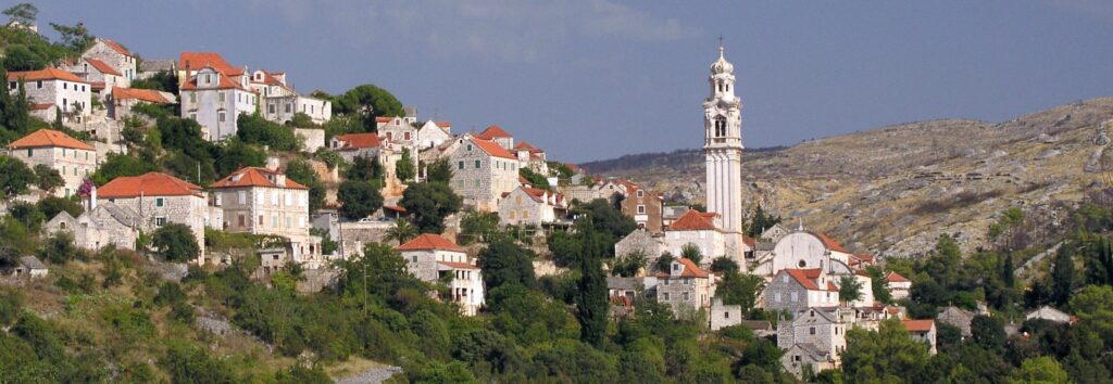 Ložišća na ostrove Brač s kamennými domami a zvonicou kostola sv. Jána a Pavla